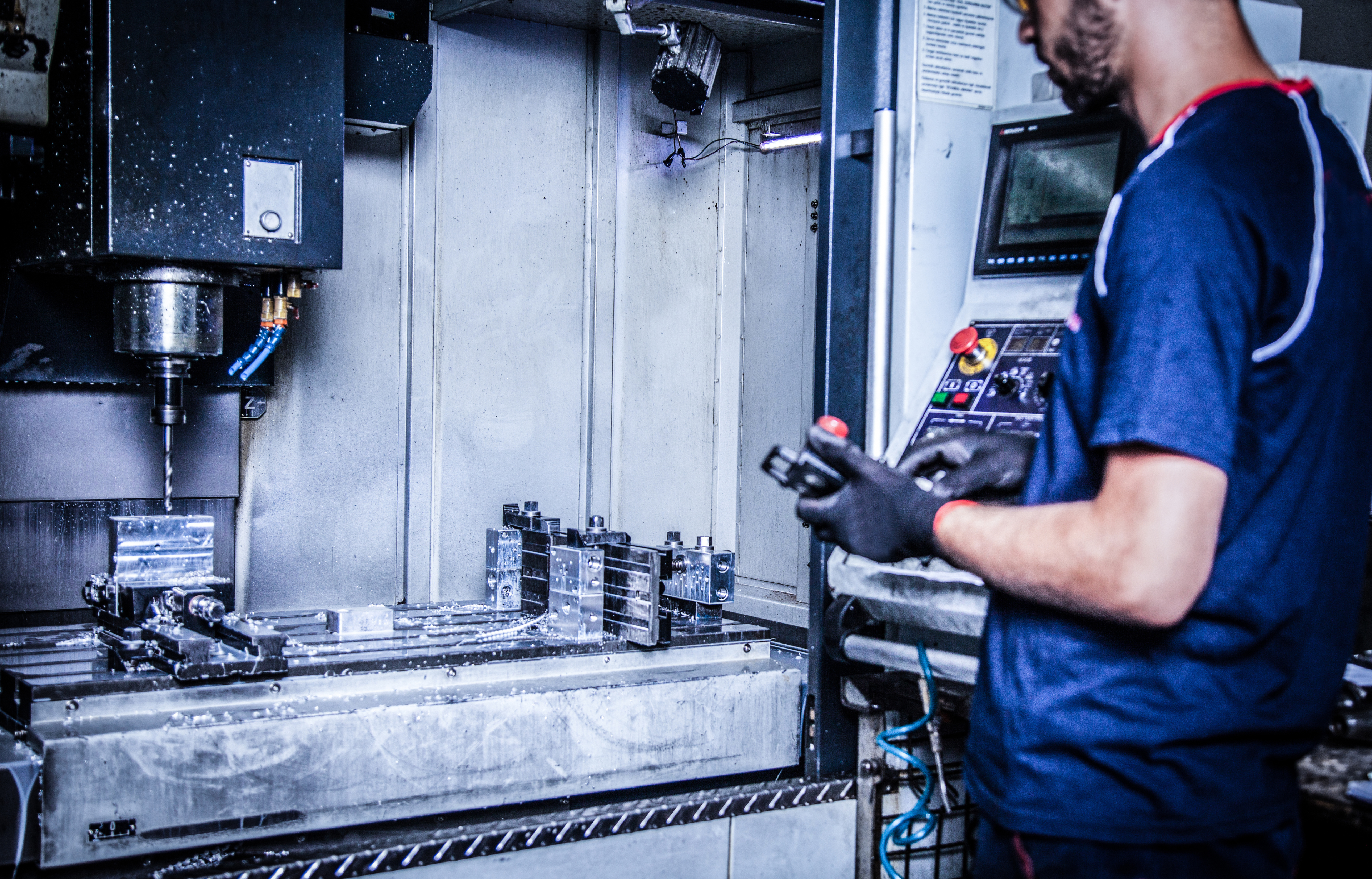 Ein Mann bedient eine CNC Maschine