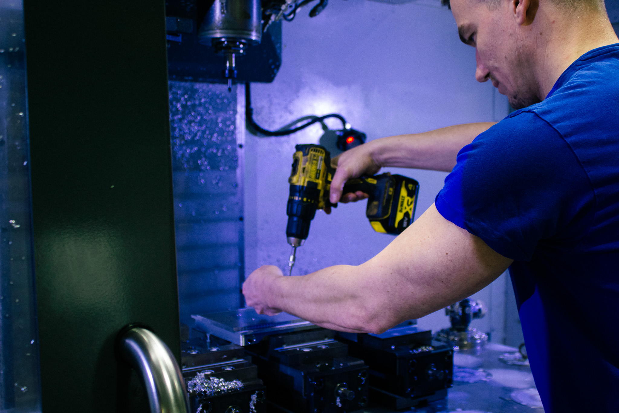 Ein Arbeiter mit einem Schraubenzieher an einer CNC Maschine