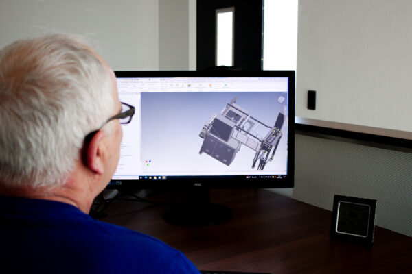 Ein Mitarbeiter des Unternemens kümmert sich am Computer um CAD/CAM Planung in Pleiskirchen