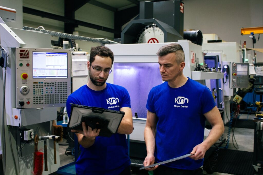 Zwei Mitarbeiter besprechen sich und schauen in ein Tablet