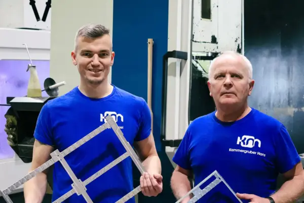 Zwei fertige Bauteile werden von Mitarbeitern hochgeladen